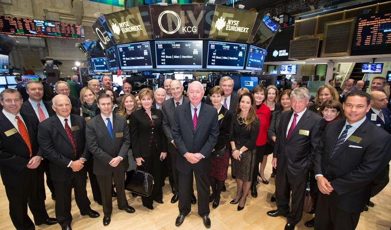 Booz Allen employees in suits standing at the center of the New York Stock Exchange