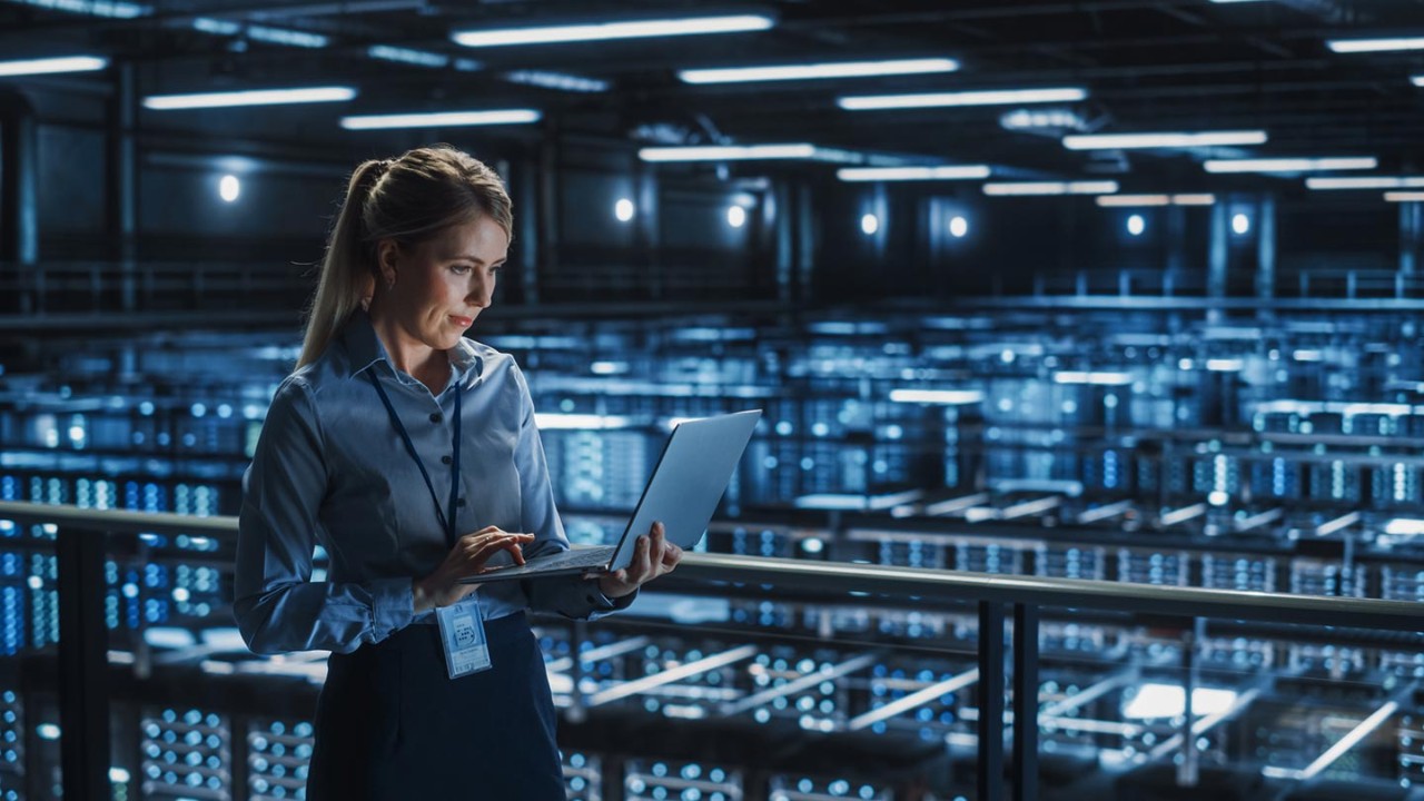 Woman working on laptop in data center